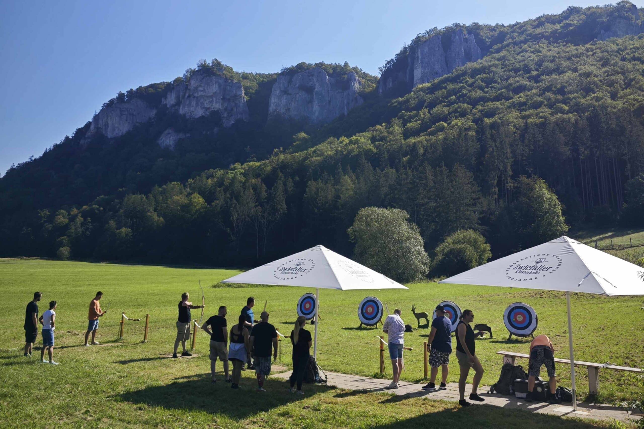 Eine Betriebsausflug beim Bogenschießen auf der Schießanlage im Donautal im Hintergrund die Felsen